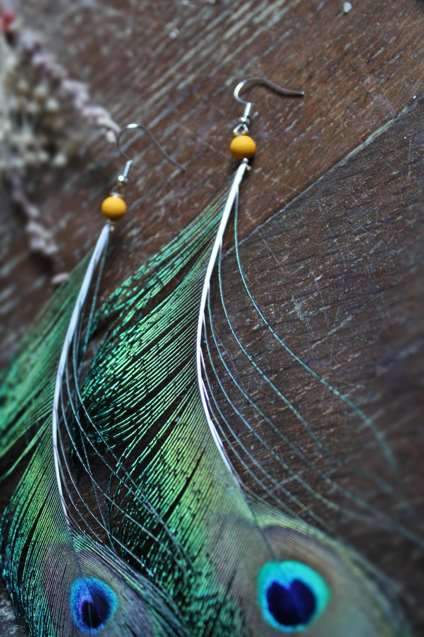 Grandes boucles d'oreilles plumes de paon et oeil et perles jaunes