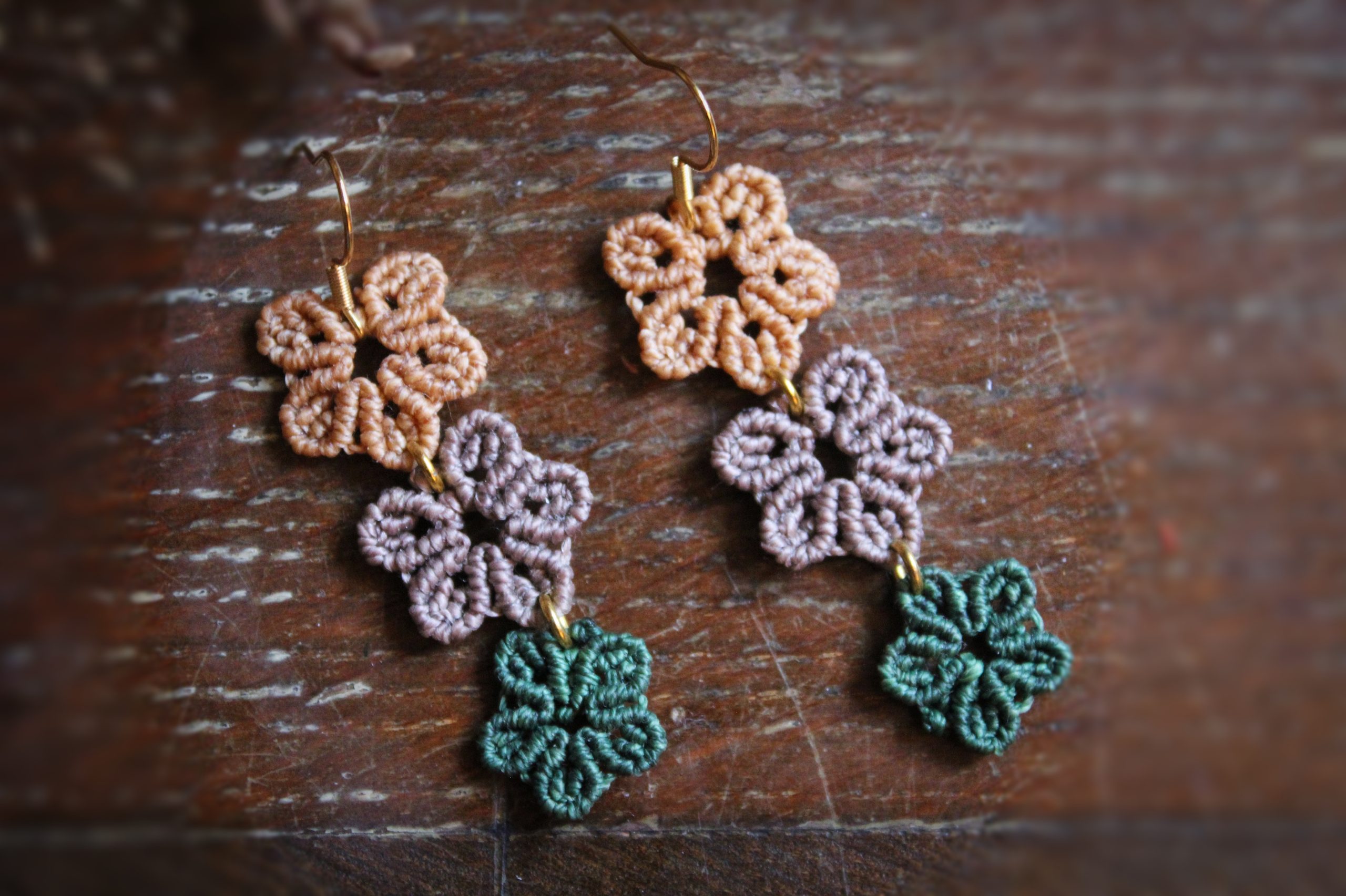 Boucles d'oreilles micro macramé représentant 3 fleurs oranges, parme et vertes