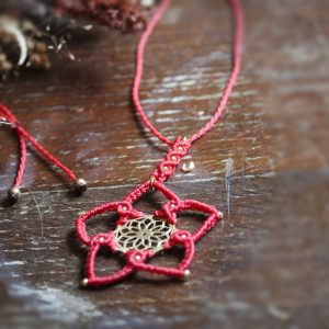 Collier en micro macramé rouge et pièce centrale en laiton représentant une fleur