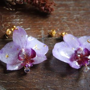 Boucles d'oreilles en véritables orchidées violettes immortalisées dans la résine avec symboles célestes dorés
