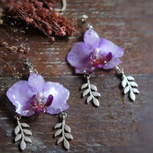 Boucles d'oreilles en véritables orchidées violettes immortalisées dans la résine avec des breloques de feuilles argentées