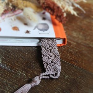Marque page mauve en micro macramé dans un livre