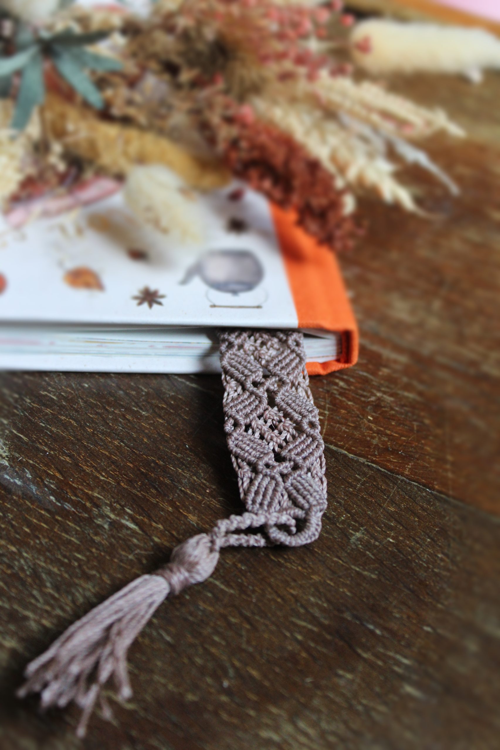Marque page mauve en micro macramé dans un livre