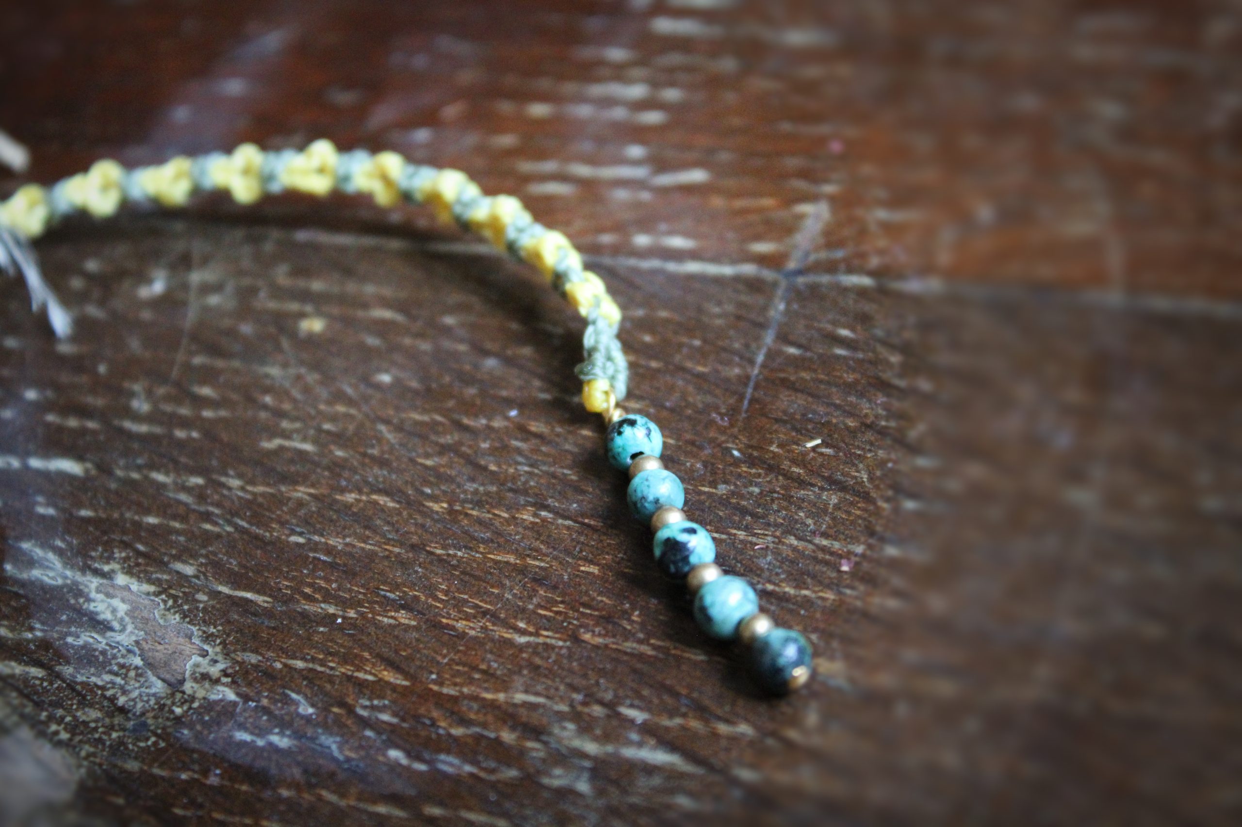 marque page en micro macramé vert et jaune représentant des fleurs et des perles de turquoise africaine