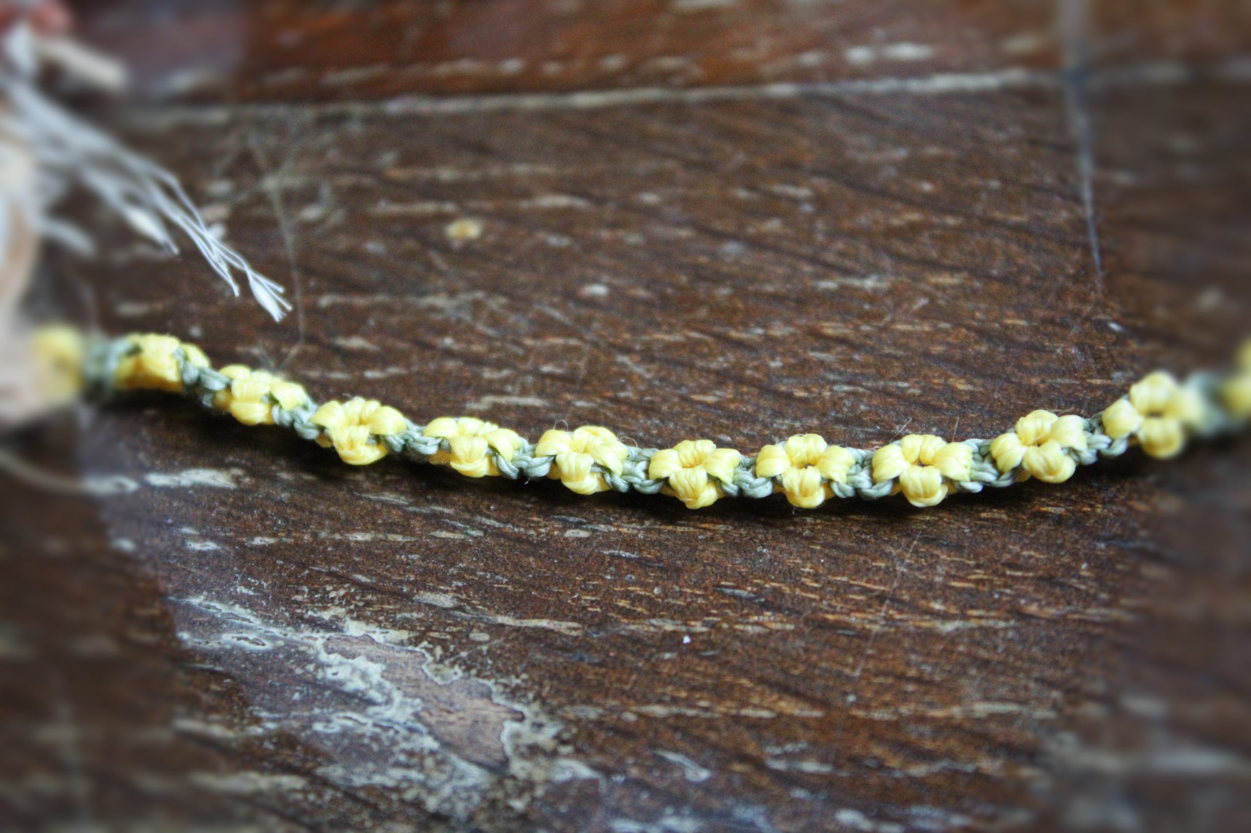 marque page en micro macramé vert et jaune représentant des fleurs