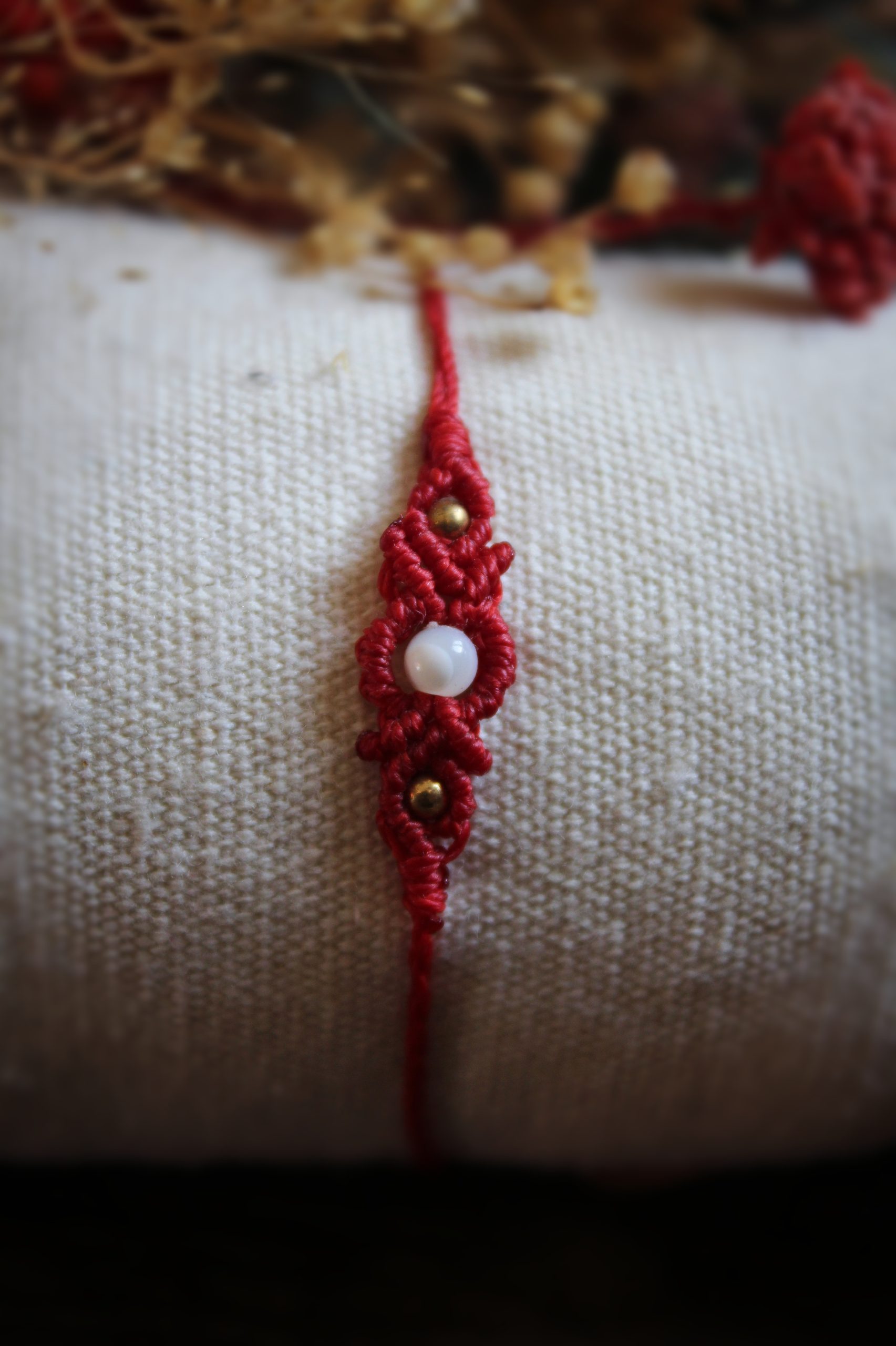 Mini bracelet en micro macramé rouge avec petite perle de nacre