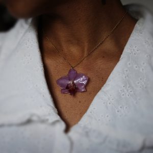 Collier porté avec une véritable orchidée résinée et chaîne dorée