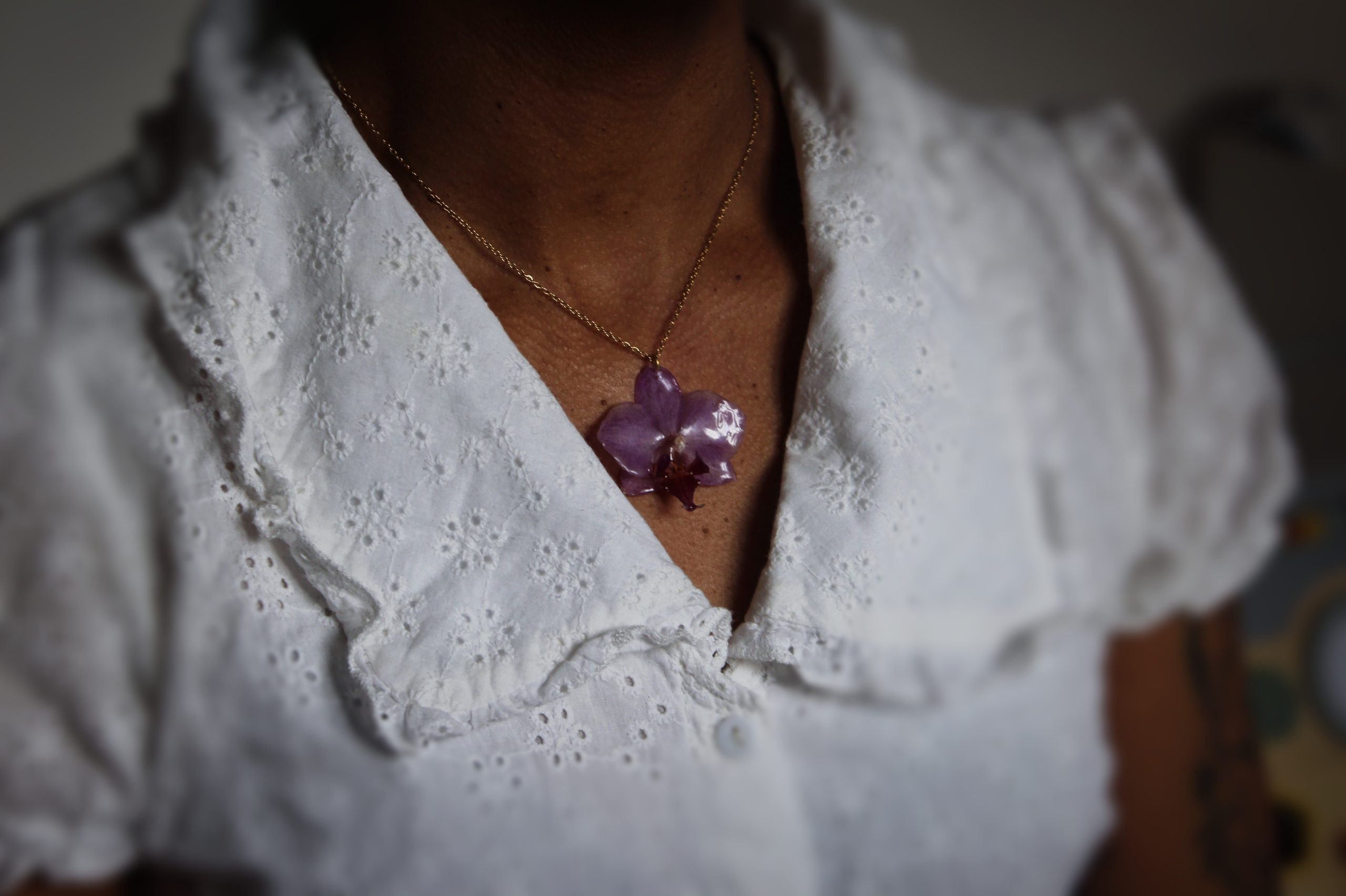 Collier porté avec une véritable orchidée résinée et chaîne dorée