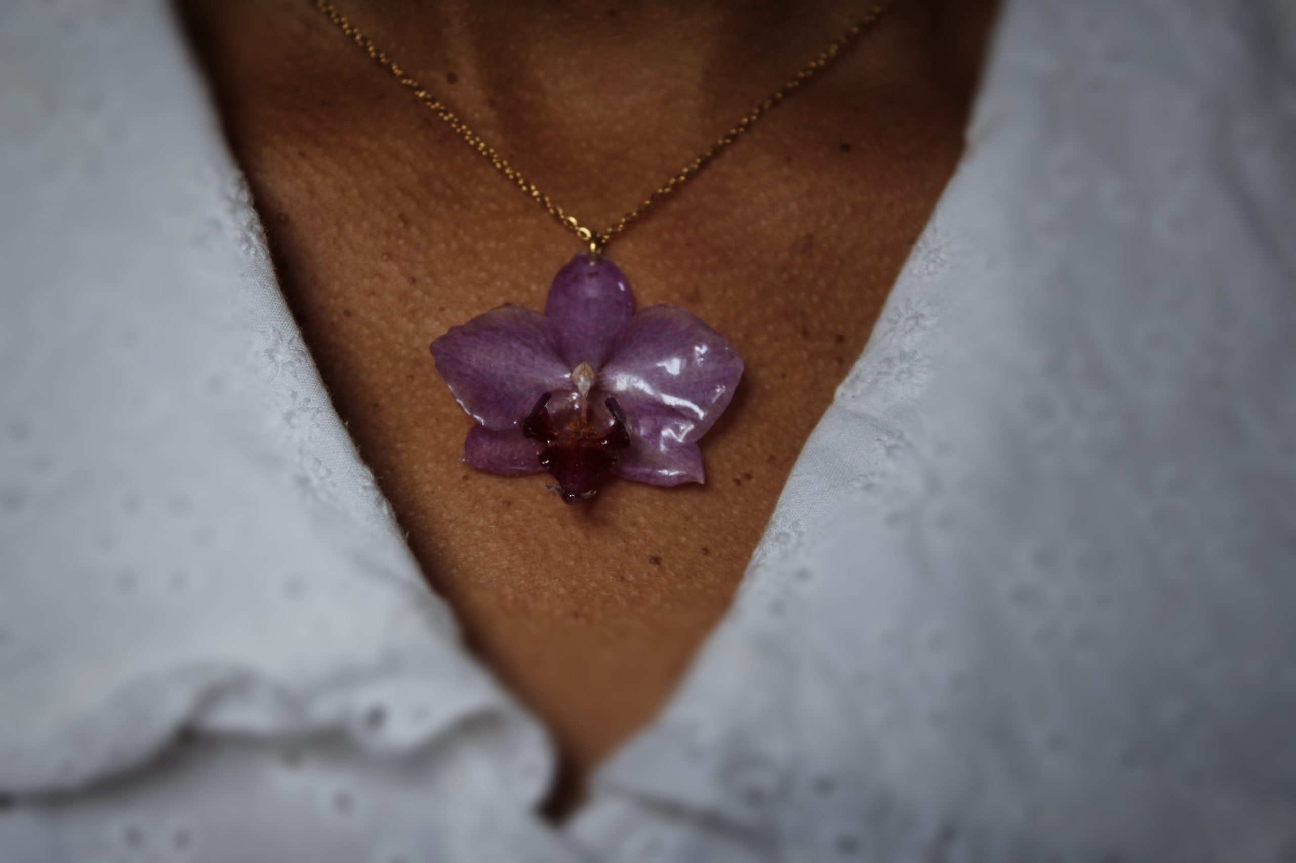 Collier porté avec une véritable orchidée résinée et chaîne dorée