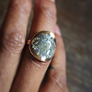 Bague ronde réglable portée avec fleurs séchées et résine