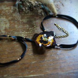 Bracelet en ruban de satin monté d'une pensée séchée et résinée et orné de perles en laiton
