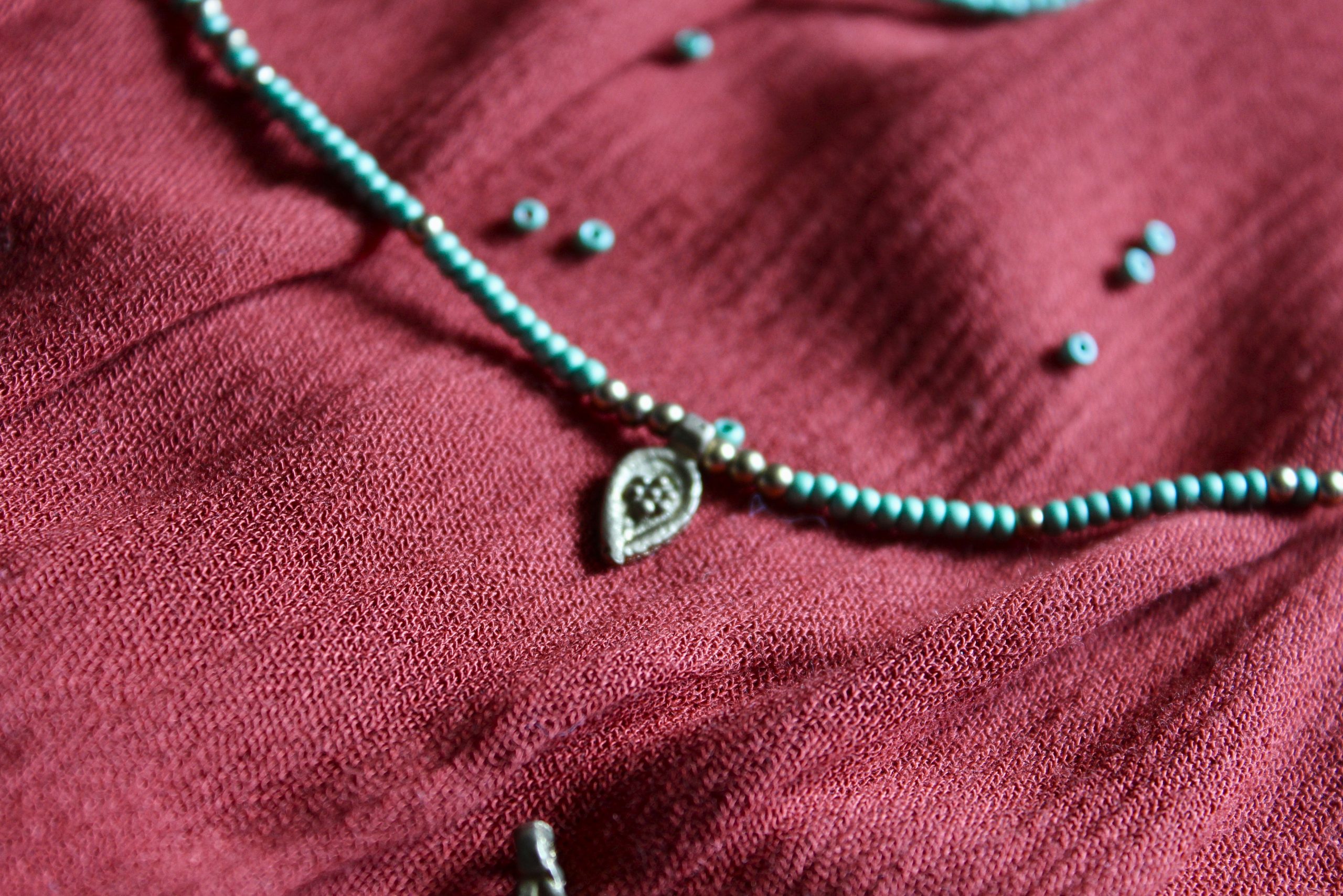 Bijou de taille avec des perles vertes et breloques dorées tibétaines