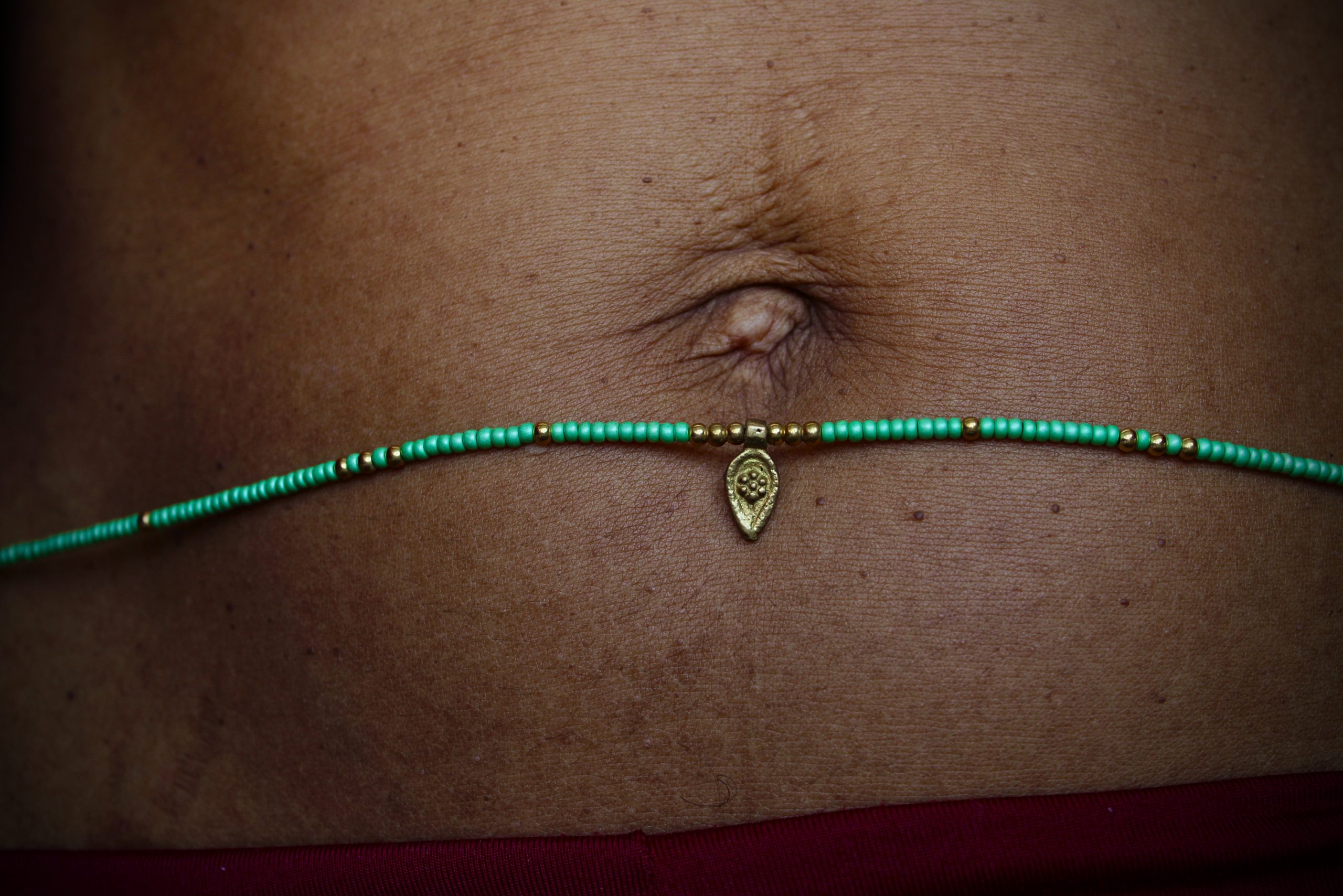 Bijou de taille avec des perles vertes et breloques dorées tibétaines