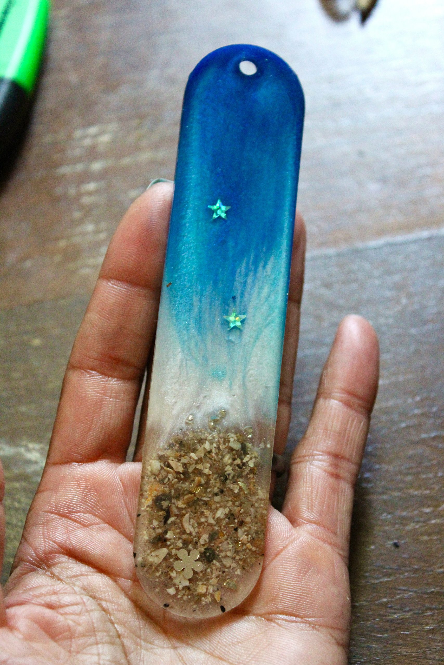Marque-page artisanal en résine avec décor de plage, sable naturel et dégradé bleu océan