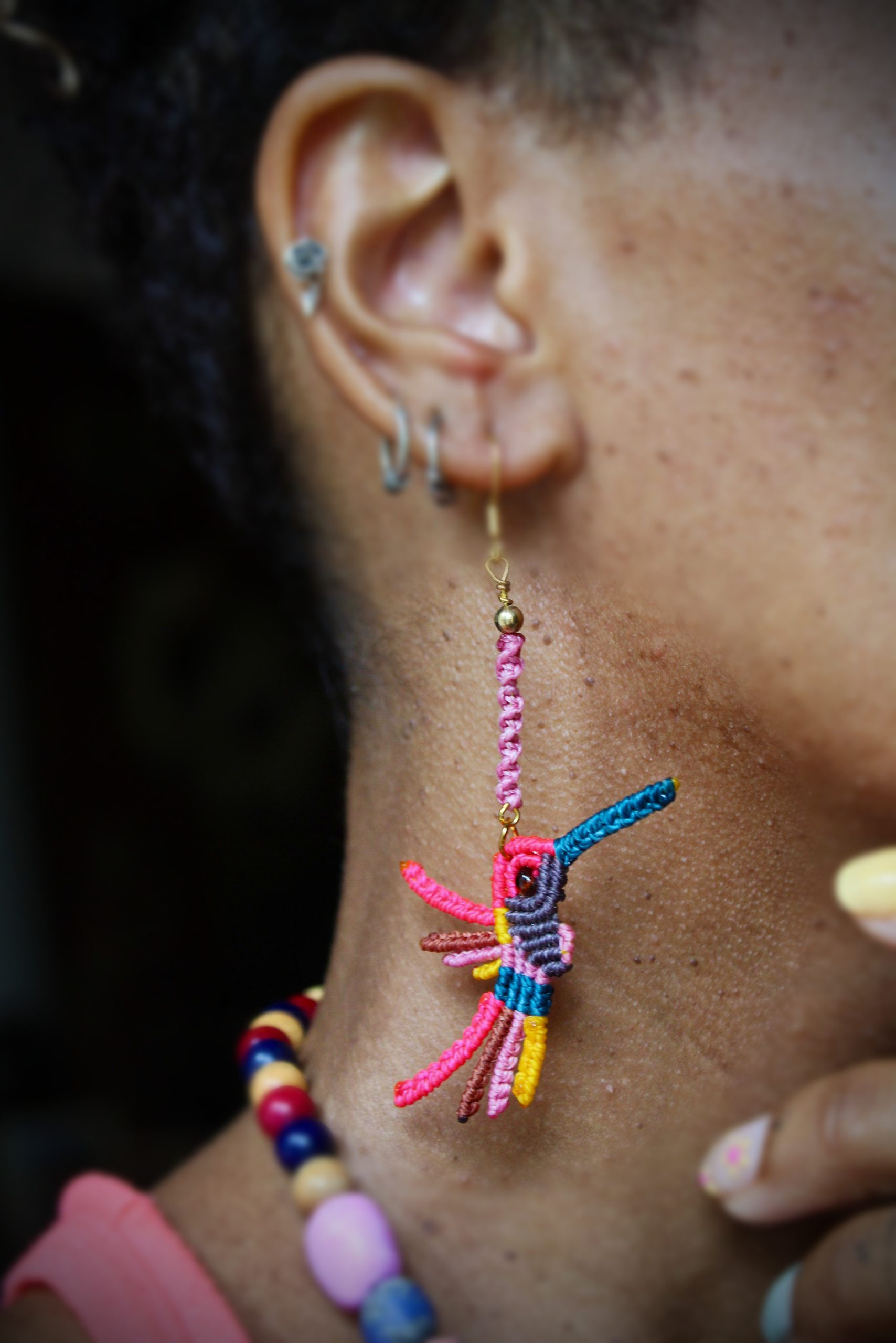 Boucles d'oreilles colibri en micro-macramé multicolore rose, bleu et jaune, faites main par Lessance