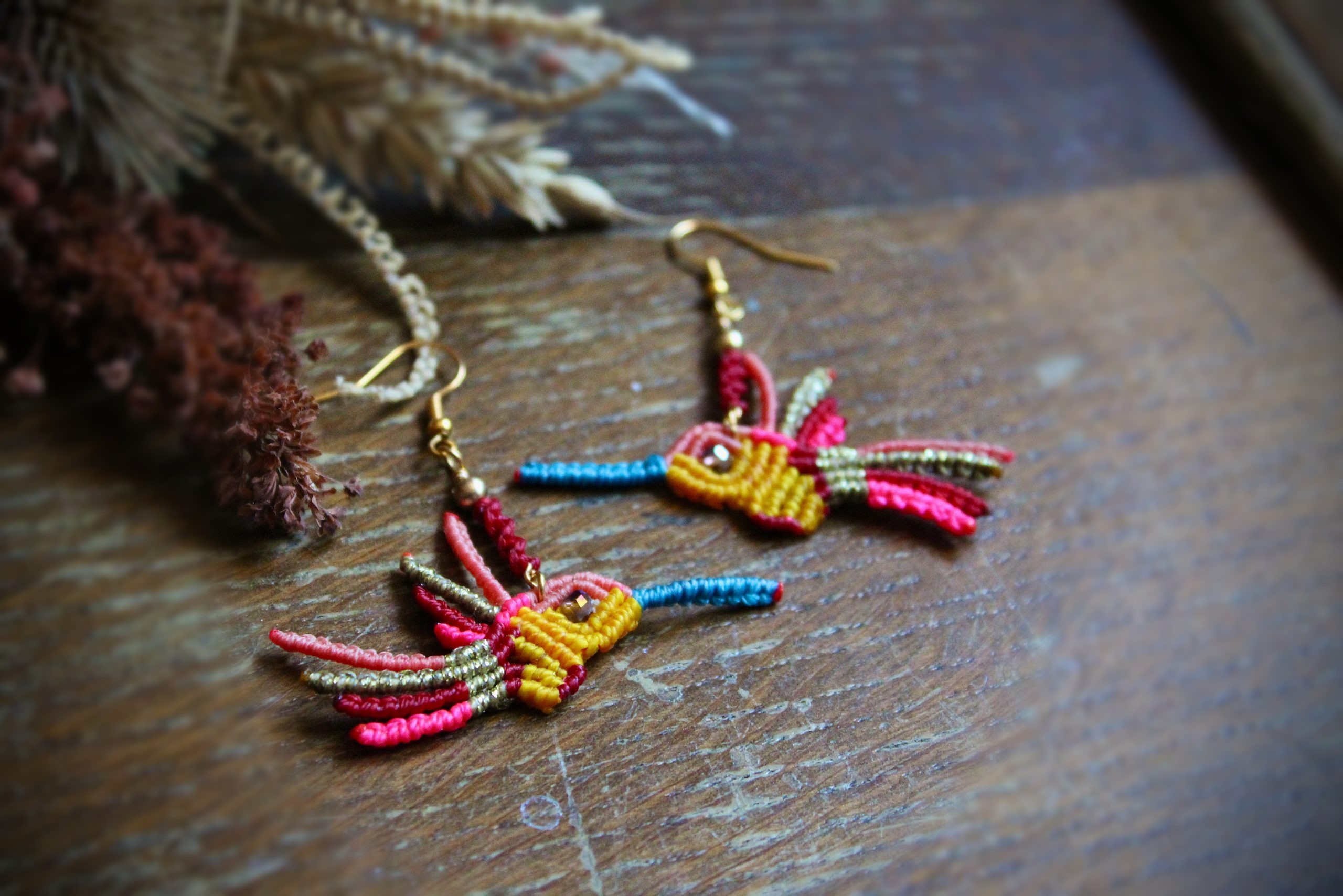 Boucles d'oreilles colibri en micro-macramé multicolore rose, bleu et jaune, faites main par Lessance