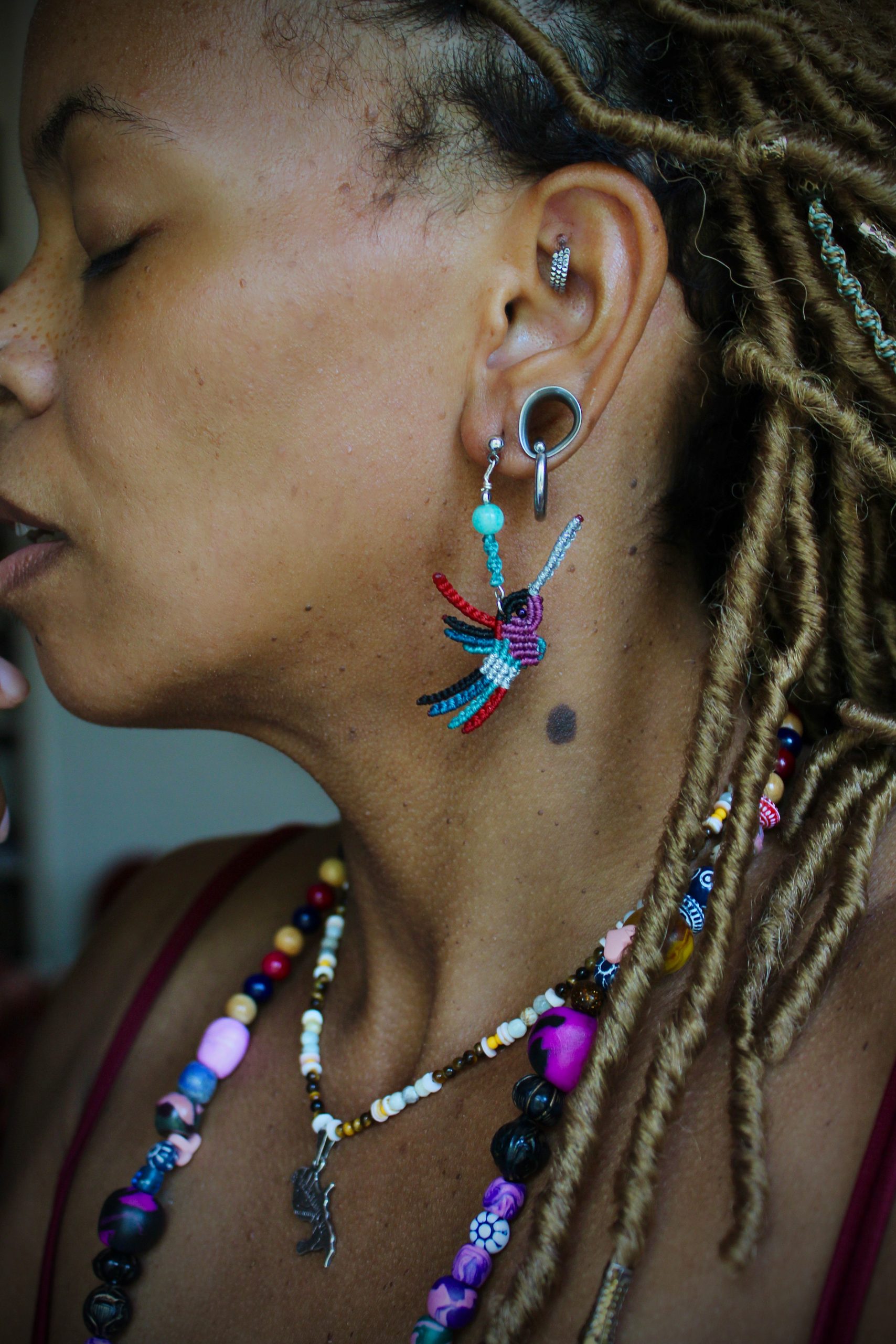 Boucles d'oreilles colibri en micro-macramé multicolore violet, bleu et rouge, faites main par Lessance