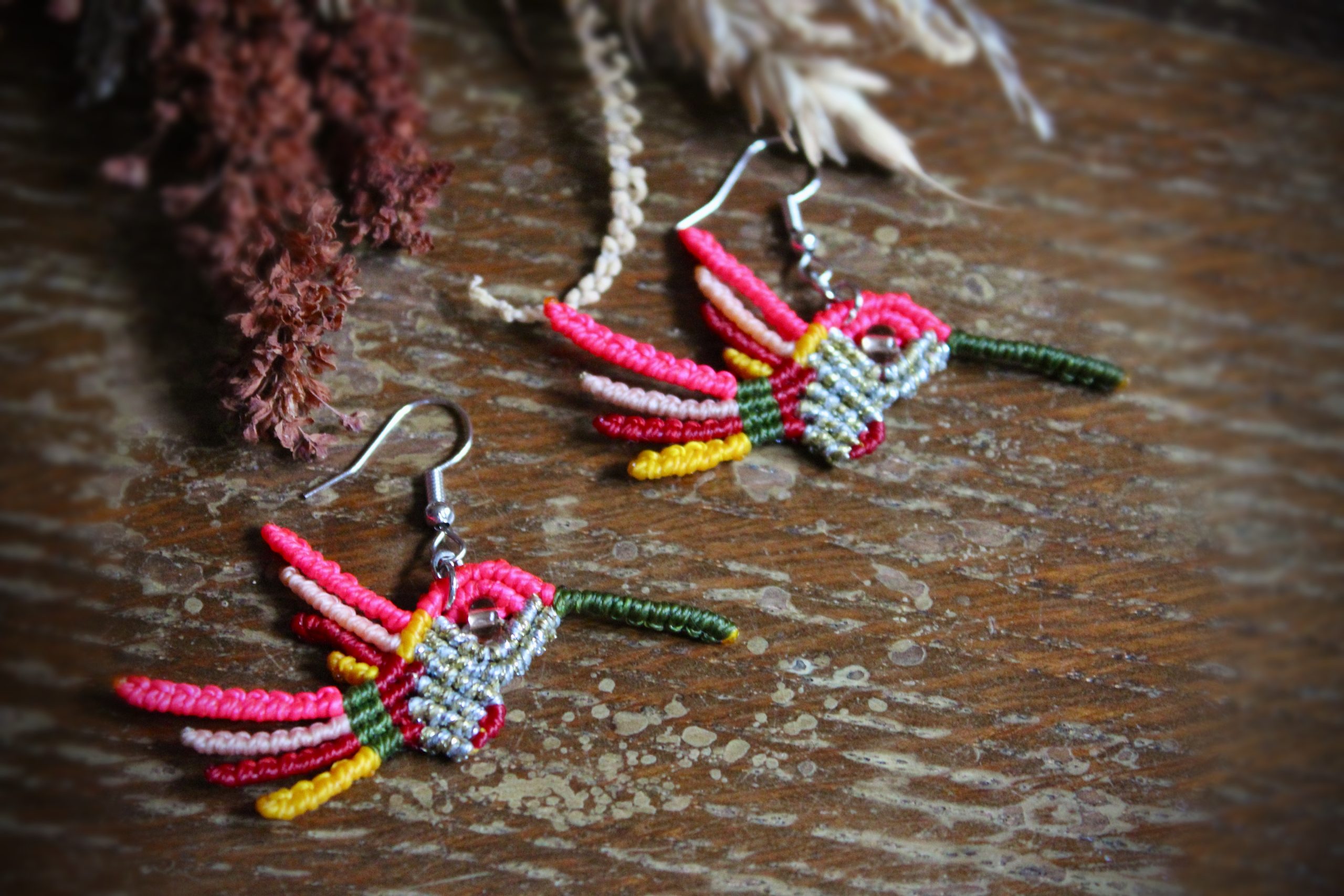 Boucles d'oreilles colibri en micro-macramé multicolore rose, vert et doré, faites main par Lessance