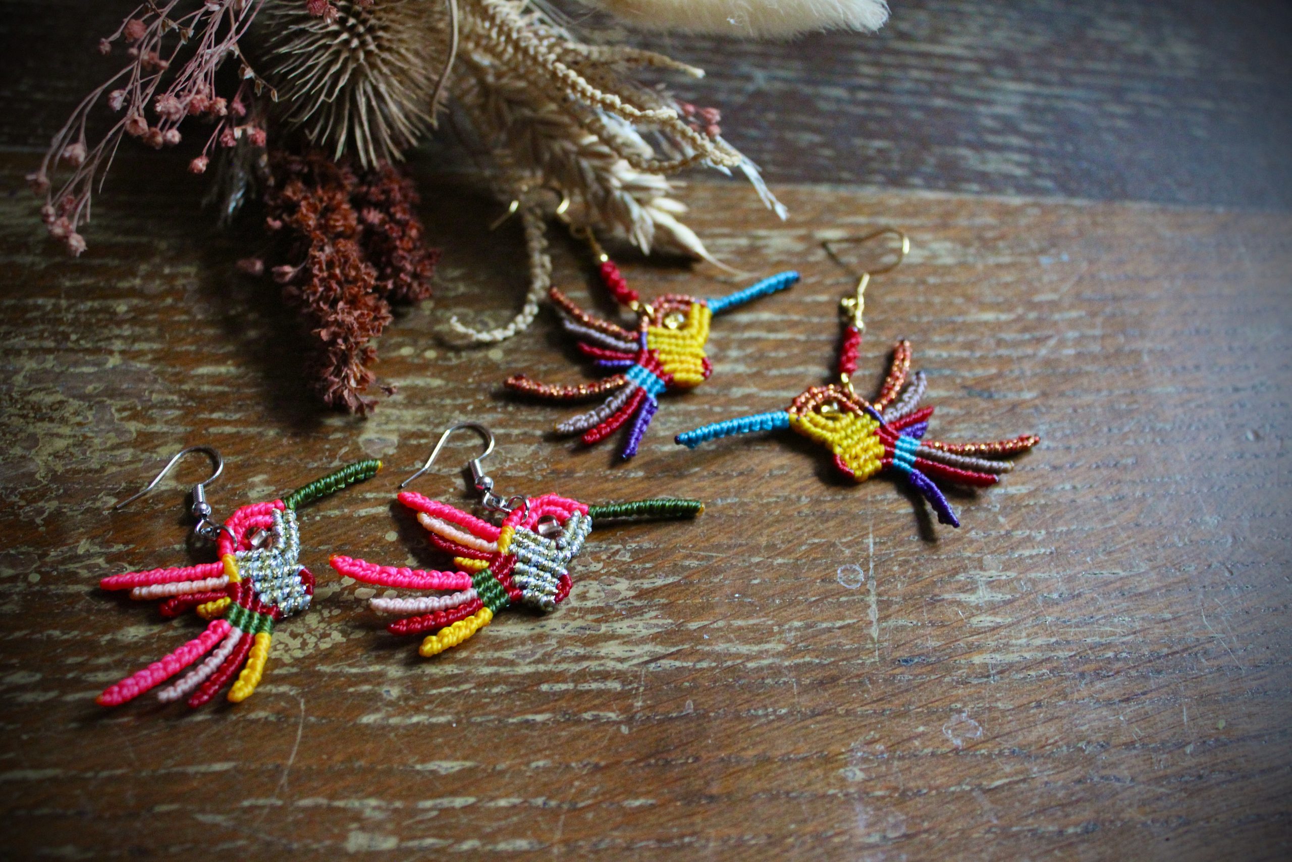 Boucles d'oreilles colibri en micro-macramé multicolore rose, vert et doré, faites main par Lessance