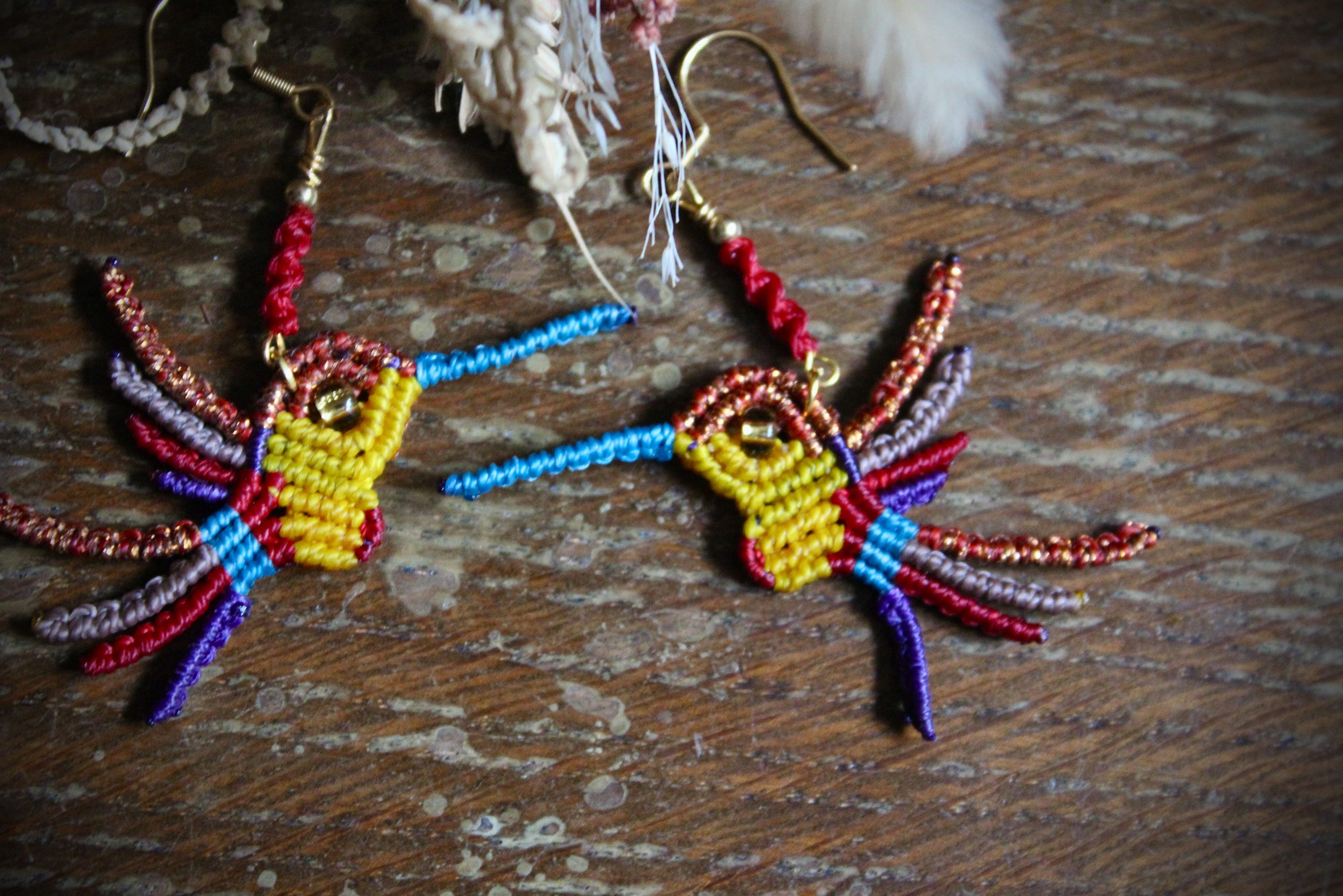 Boucles d'oreilles colibri en micro-macramé multicolore rose, vert et doré, faites main par Lessance
