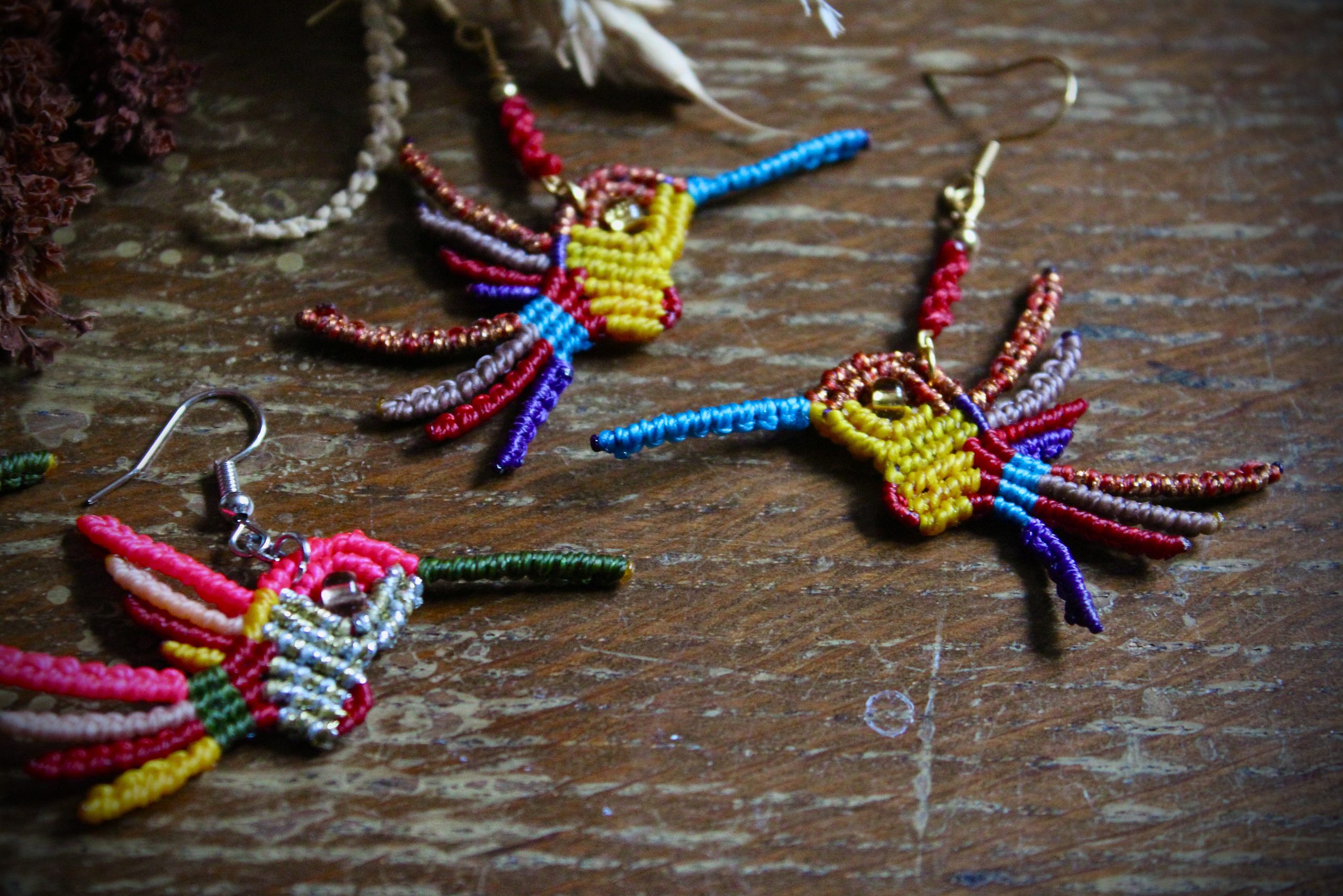 Boucles d'oreilles colibri en micro-macramé multicolore bleu, cuivre et jaune, faites main par Lessance